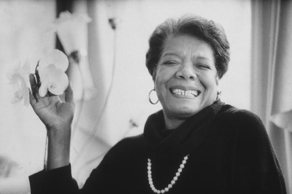 8th January 1993: Headshot portrait of African-American author Maya Angelou wearing black sweater with a pearl necklace, smiling and holding flowers in one hand. (Photo by Stephen Matteson Jr/New York Times Co./Getty Images)